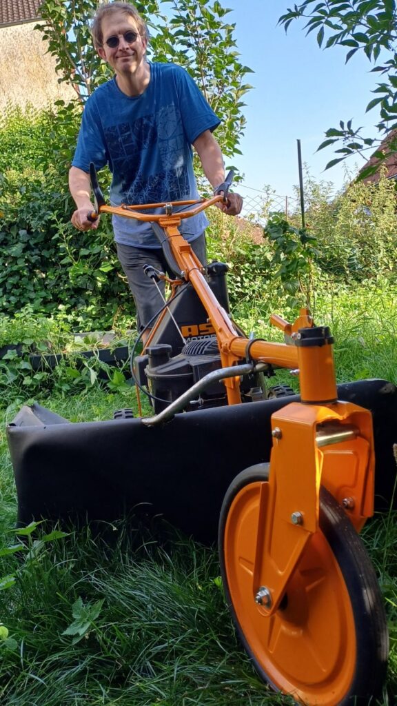 Uli Zeller, der Autor dieses Artikels, beim Rasenmähen mit seinem Hochgrasmäher. Im Beitrag erzählt er, wie man mit verschiedenen Mitteln Männer mit Demenz abholen kann.